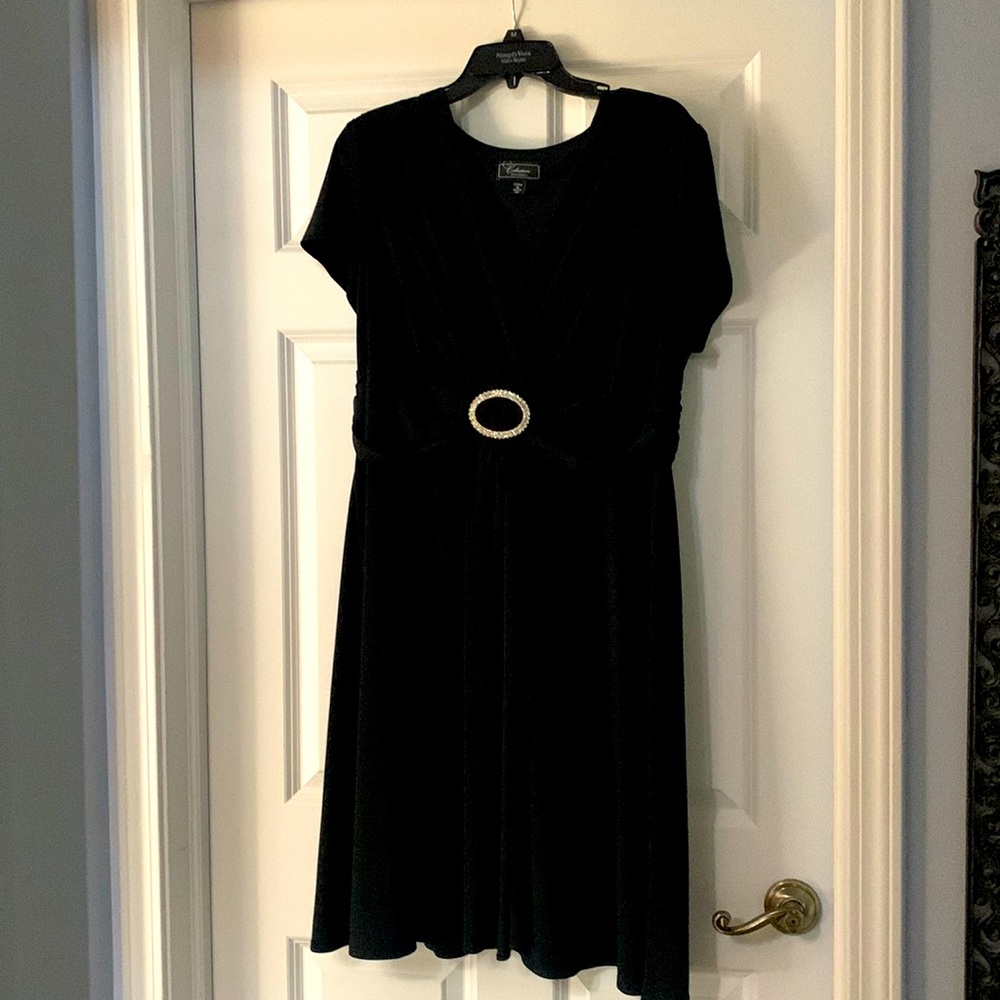 Calf-length black dress. Crystal buckle detail at empire waist.